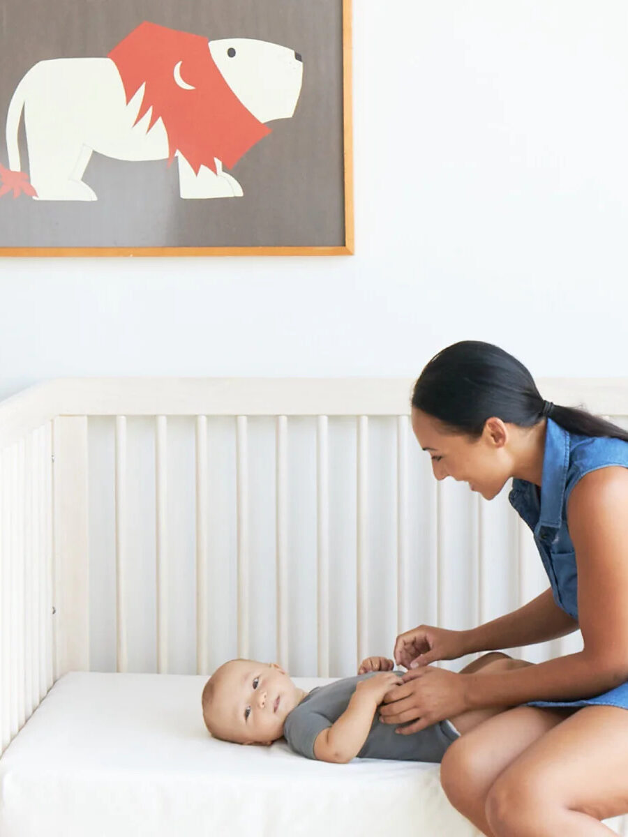 A woman plays with a baby on a mattress