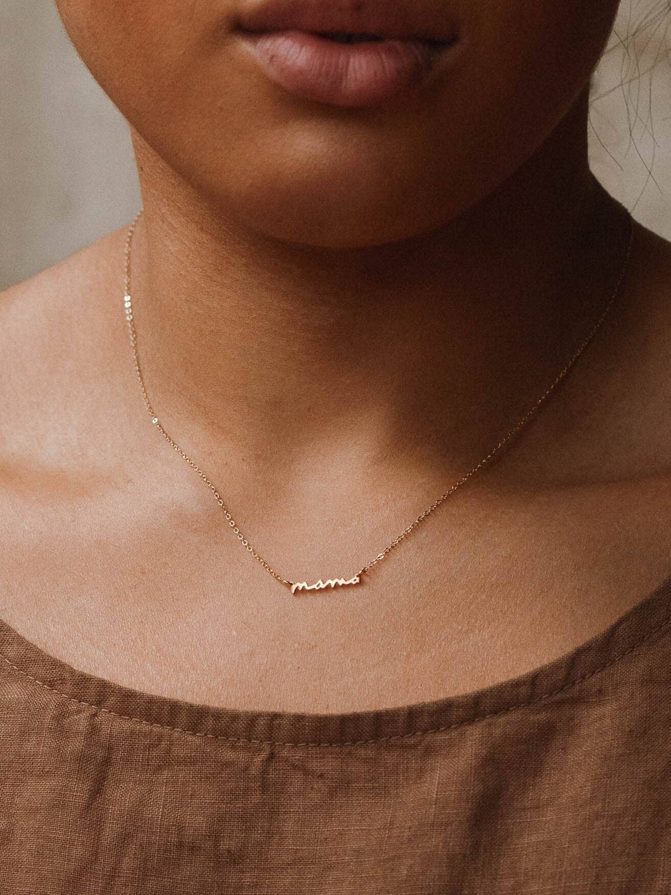 GLDN gold "mama" necklace on a model.