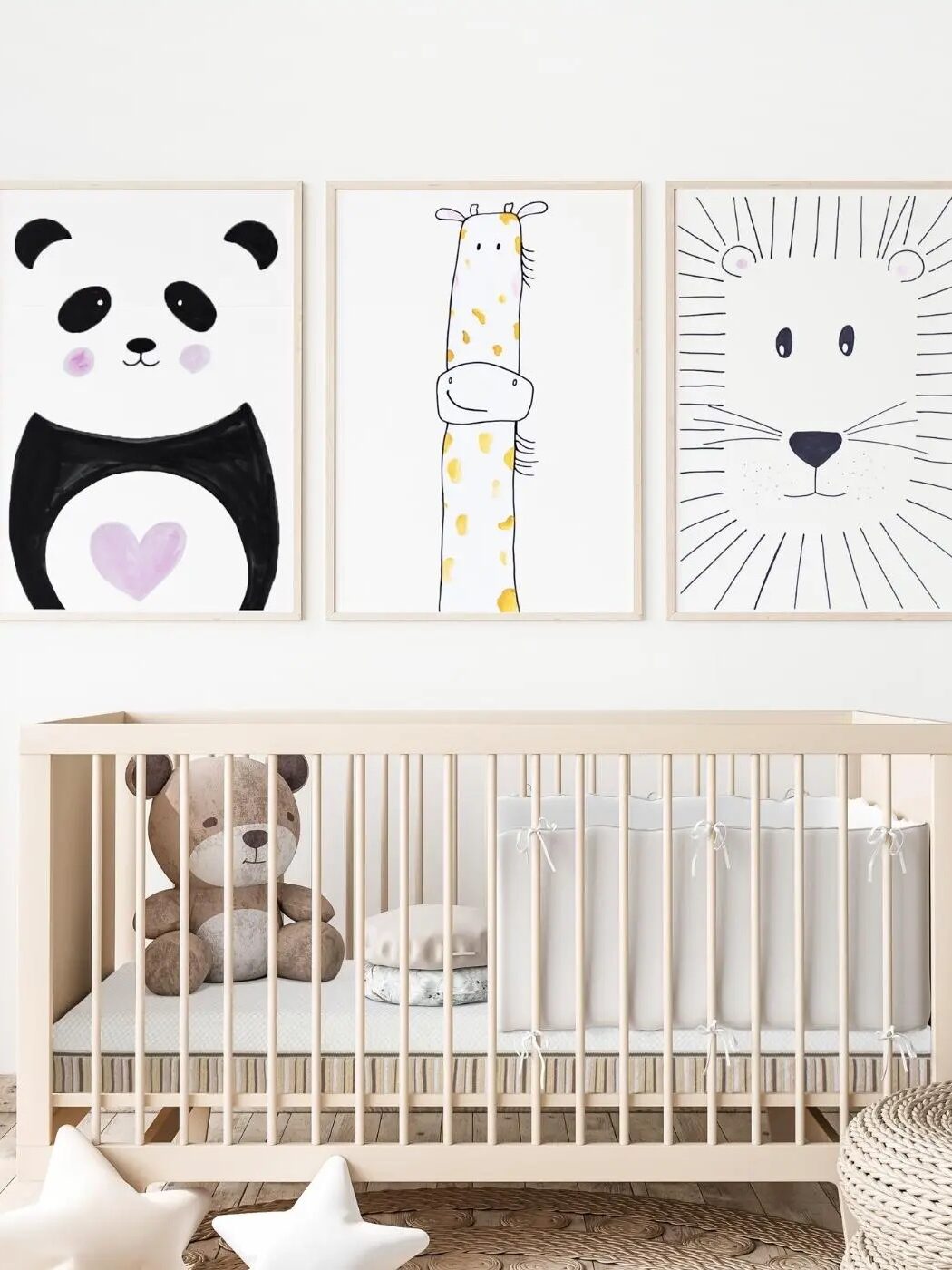 A crib with toys and framed animal illustrations above it.