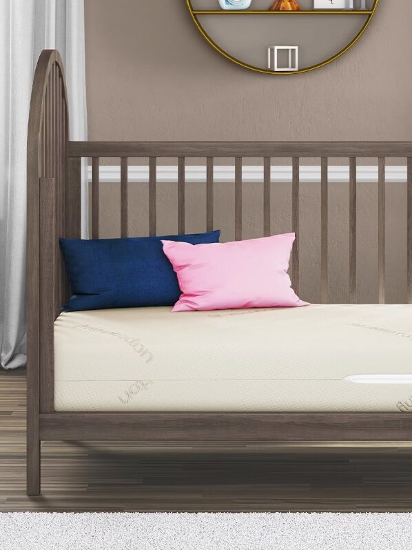 A crib and mattress with two pillows