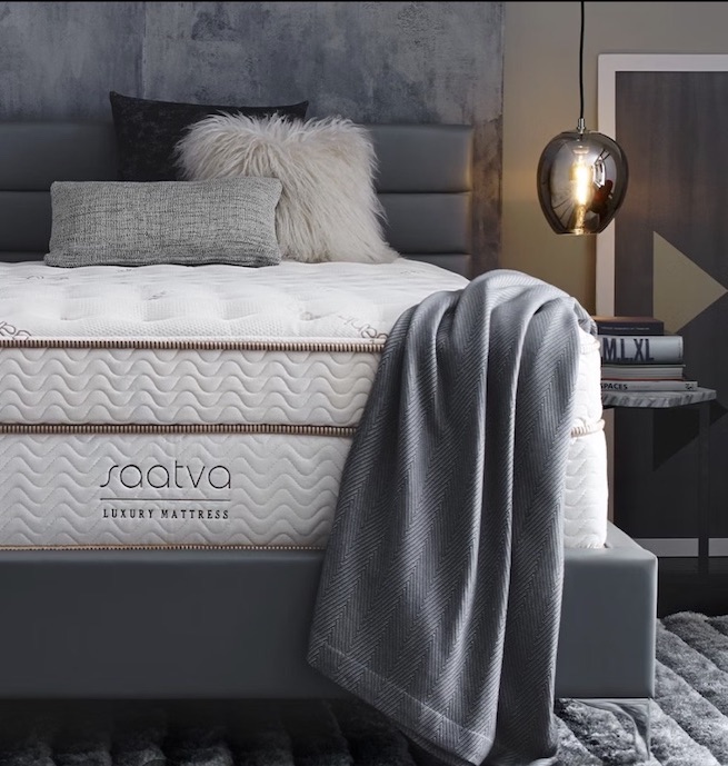A Saatva mattress with a blanket on it.