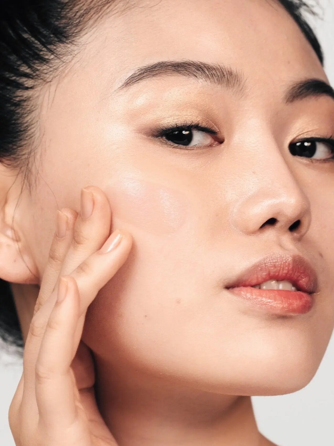 A close up of an Asian model testing the product on her cheek