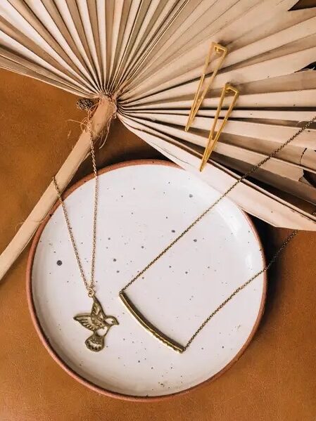 Two necklaces are displayed in a ceramic plate.