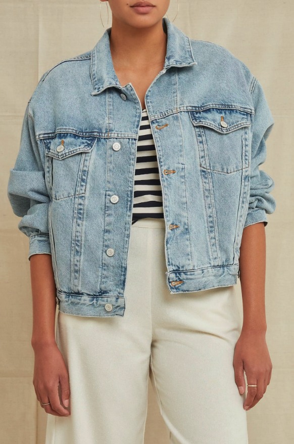 Model wearing AGOLDE light denim oversized jacket with a back and white striped shirt underneath